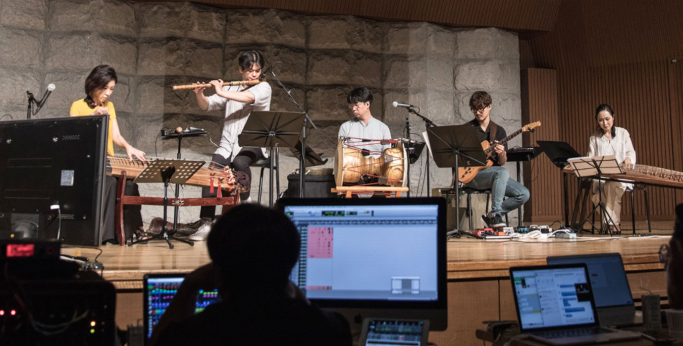 Image of a band playing on stage together.